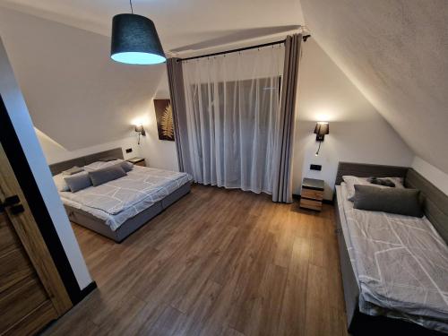 um quarto com 2 camas e uma grande janela em Przy Ostrewkach Małe Ciche em Murzasichle