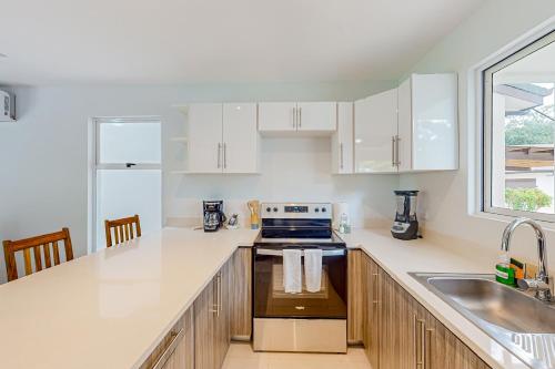 a kitchen with white cabinets and a sink at Ciudad del Mar 71 in Jacó