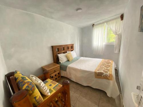 1 dormitorio con cama, sofá y ventana en Casa del bosque 2, en Valle de Bravo
