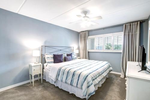 Dormitorio azul con cama y TV en 112 Oceans Of Amelia en Amelia Island