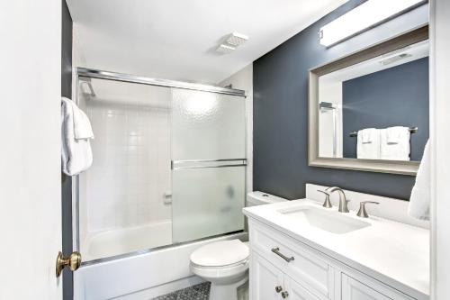 a bathroom with a toilet and a sink and a mirror at 112 Oceans Of Amelia in Amelia Island