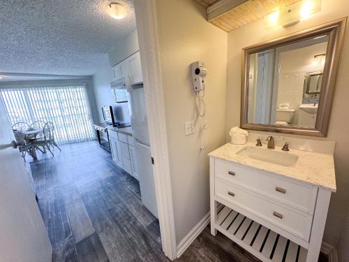 a bathroom with a sink and a mirror and a kitchen at Aqua Beach Hotel in Wildwood Crest