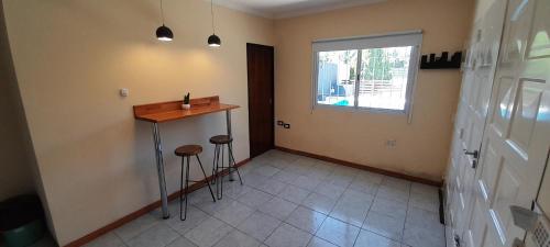 a kitchen with a counter and stools in a room at Tranquilidad Total in Roldán