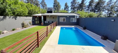 a house with a swimming pool next to a fence at Tranquilidad Total in Roldán