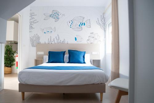 a bedroom with a large bed with blue pillows at Apartamentos Barlovento in Puerto de Mazarrón