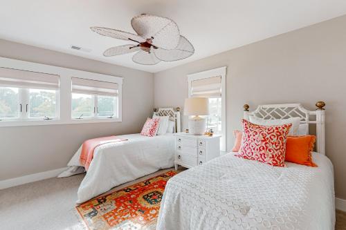 a bedroom with two beds and a ceiling fan at Villa Christol in Bluffton