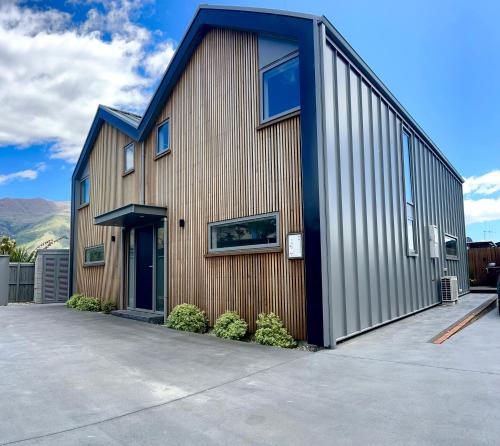 a large wooden building with a gambrel roof at Aspiring View Apartments in Wanaka