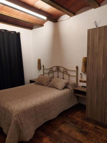 a bedroom with a bed and a black curtain at Casa Rural Miravella in Castril