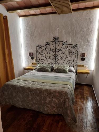 a bedroom with a large bed with a metal headboard at Casa Rural Miravella in Castril