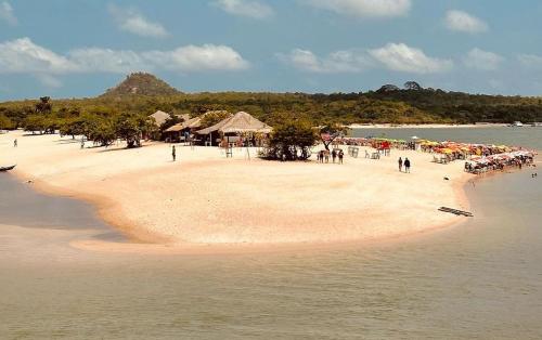 una playa con muchas sombrillas y gente en ella en Hospedagem da Lua no Sobrado Delas, en Alter do Chao