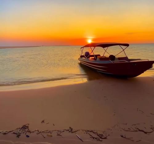 ein Boot am Strand bei Sonnenuntergang in der Unterkunft Hospedagem da Lua no Sobrado Delas in Alter do Chao