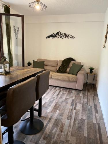 un salon avec un canapé et une table dans l'établissement La Tanière de Sven - Vue Montagne, à Saint-Nicolas-la-Chapelle