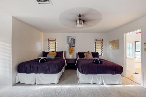 two beds in a room with white walls at Cactus Cove in Scottsdale