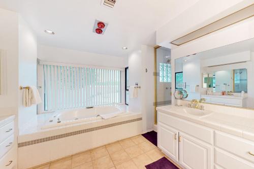a bathroom with a large tub and a large window at Cactus Cove in Scottsdale