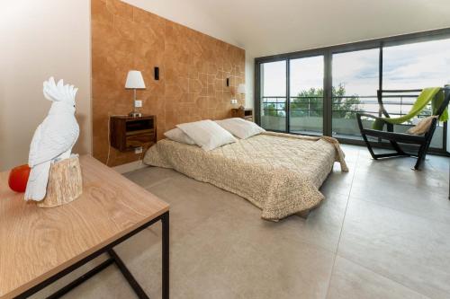 - une chambre avec un lit et une table avec une statue de perroquet dans l'établissement Villa Bellevue, à Sète