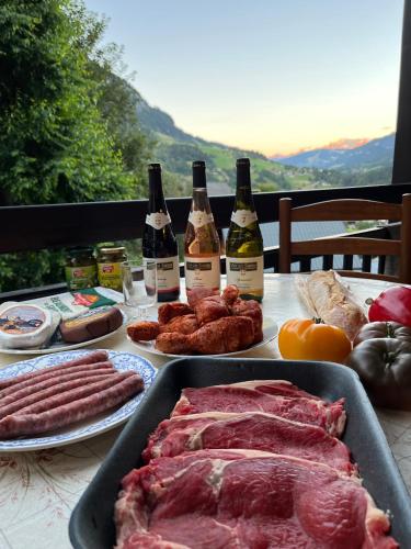- une table remplie de viandes et de bouteilles de vin dans l'établissement La Tanière de Sven - Vue Montagne, à Saint-Nicolas-la-Chapelle