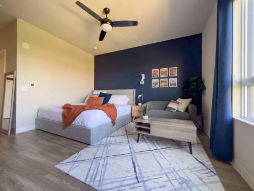 um quarto com uma cama, um sofá e uma ventoinha de tecto em King Bed Studio Rooftop Views em Boise