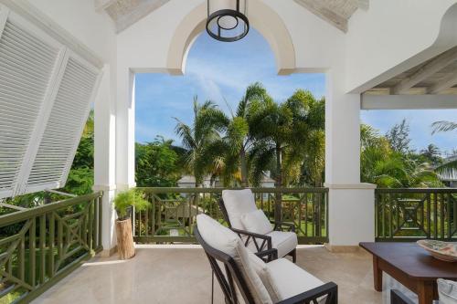 ein Zimmer mit Balkon mit Stühlen und Tisch in der Unterkunft Royal Westmoreland - Sugar Cane Ridge 3 townhouse in Saint James
