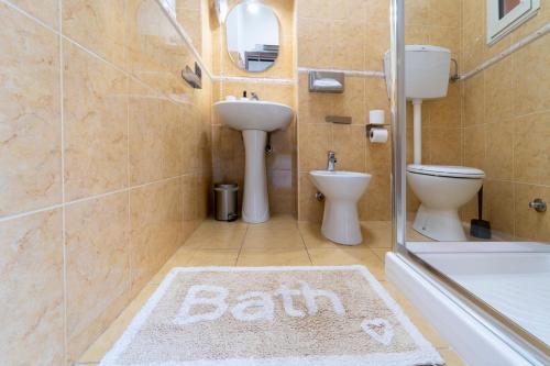 a bathroom with a sink and a toilet and a bath rug at B&B Eraclio in Barletta