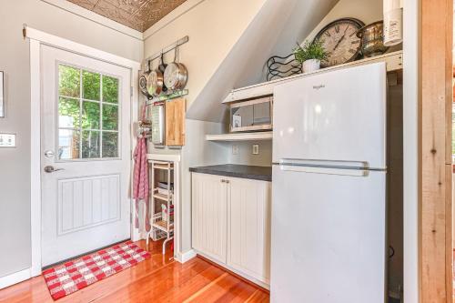 a kitchen with a white refrigerator and a door at Ferry Viewer Cottage in Point Roberts