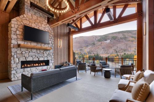 a living room with a stone fireplace and a tv at Residence Inn by Marriott Vail in Vail