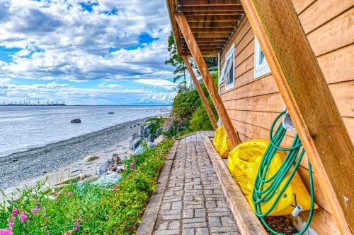 a house with a staircase leading to the beach at Ferry Viewer Cottage in Point Roberts
