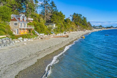 a house on a beach next to the water at Ferry Viewer Cottage in Point Roberts