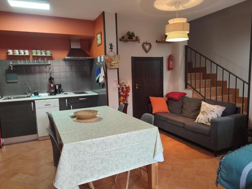 eine Küche und ein Wohnzimmer mit einem Tisch und einem Sofa in der Unterkunft La Casita de Pedraza in Segovia
