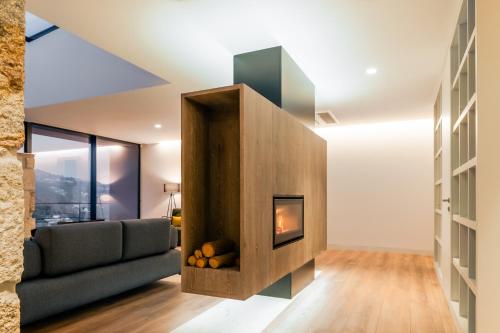 a living room with a fireplace and a couch at Douro Country House in Cinfães
