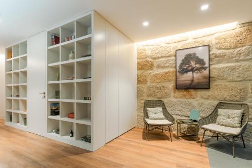 a room with two chairs and a stone wall at Douro Country House in Cinfães