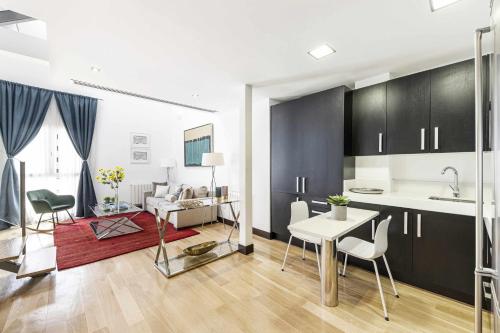 a kitchen and living room with a table and chairs at Luxury duplex close to Gran Via Colon in Madrid