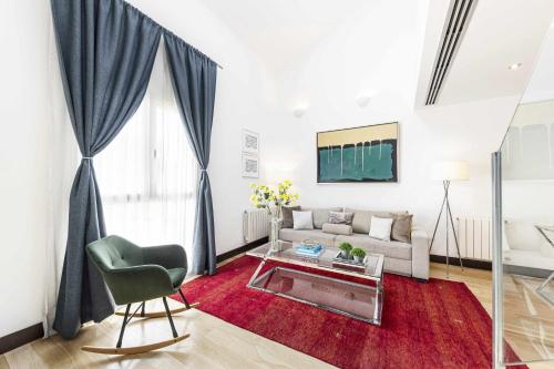 a living room with a couch and a table at Luxury duplex close to Gran Via Colon in Madrid