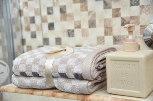 a stack of towels on a counter with a soap dispenser at Budva OLD TOWN 4 apartment in Budva