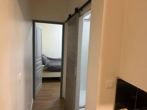 um corredor com um espelho e uma cama num quarto em appartement Corentin Cariou em Paris