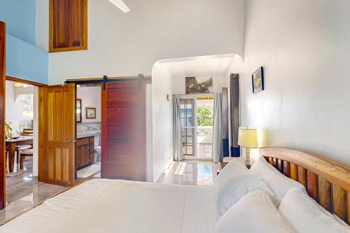 a bedroom with a bed and a kitchen at Casa Tranquila in Caye Caulker