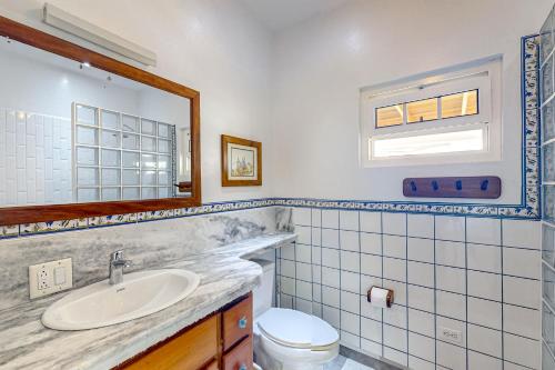 y baño con lavabo, aseo y espejo. en Casa Tranquila, en Caye Caulker