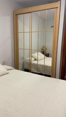 トラマカスティリャ・デ・テナにあるApartamento La Pinadaのベッドルーム(大きな鏡、ベッド付)
