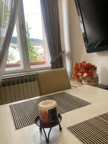 a candle sitting on a table in a room with windows at Apartment Romana in Sarajevo
