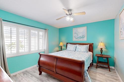 a bedroom with blue walls and a bed and a ceiling fan at Gulf Coast Dreaming in Venice