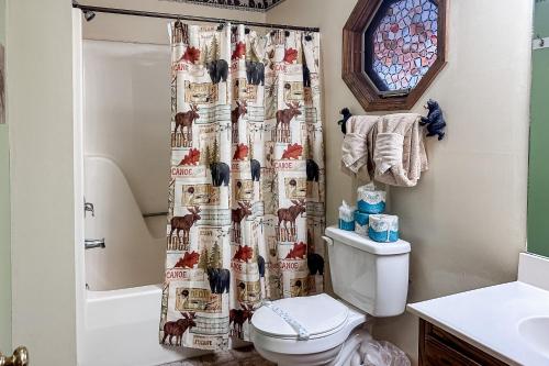 a bathroom with a shower curtain with chickens on it at Big Bear Hug Cabin in Pigeon Forge