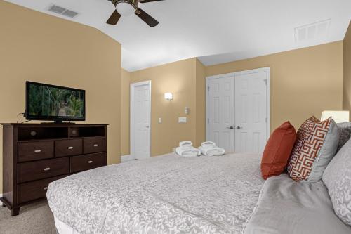 a bedroom with a bed and a flat screen tv at Luxurious Townhome - 5 minutes from Disney in Orlando