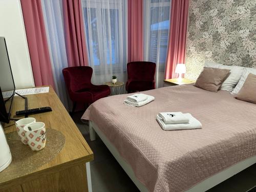 a bedroom with a bed with two towels on it at WILLA DobraNocka in Szklarska Poręba