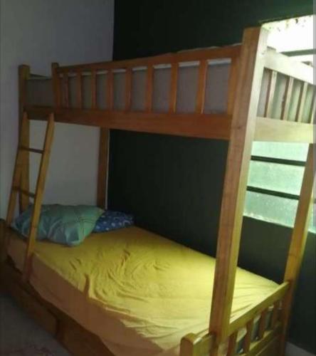 Ce lit superposé se trouve dans un dortoir doté d'un lit jaune. dans l'établissement Alojamiento JL, à Ciudad del Este