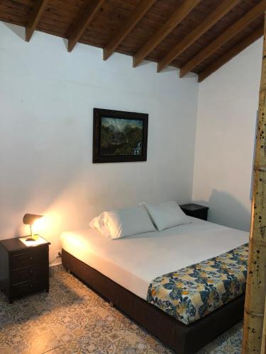 a bedroom with a bed and a lamp on a table at Eco Hotel Terrabella in Santa Elena