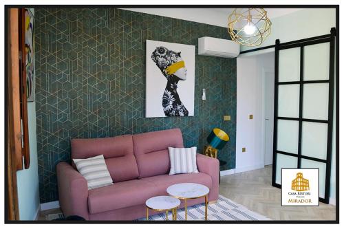a living room with a pink couch and a wall at Casa Rístori Mirador in Manzanares