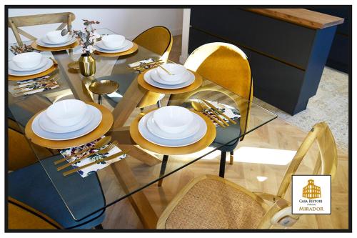 a dining room table with white dishes on it at Casa Rístori Mirador in Manzanares