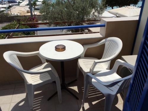 a table and four chairs on a balcony at Rozos Hotel in Porto Heli