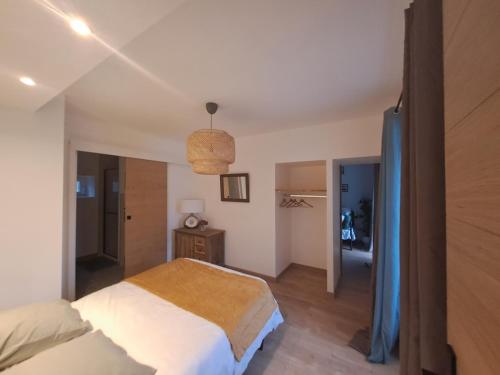 una camera da letto con un grande letto e un corridoio di La Charmille a Montagnieu