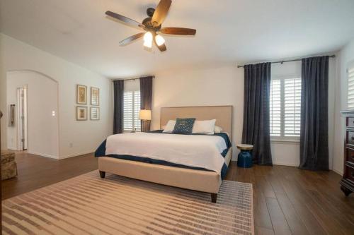 a bedroom with a bed and a ceiling fan at Amazing home with custom-built pool in El Paso