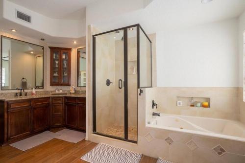 a bathroom with a shower and a bath tub at Amazing home with custom-built pool in El Paso